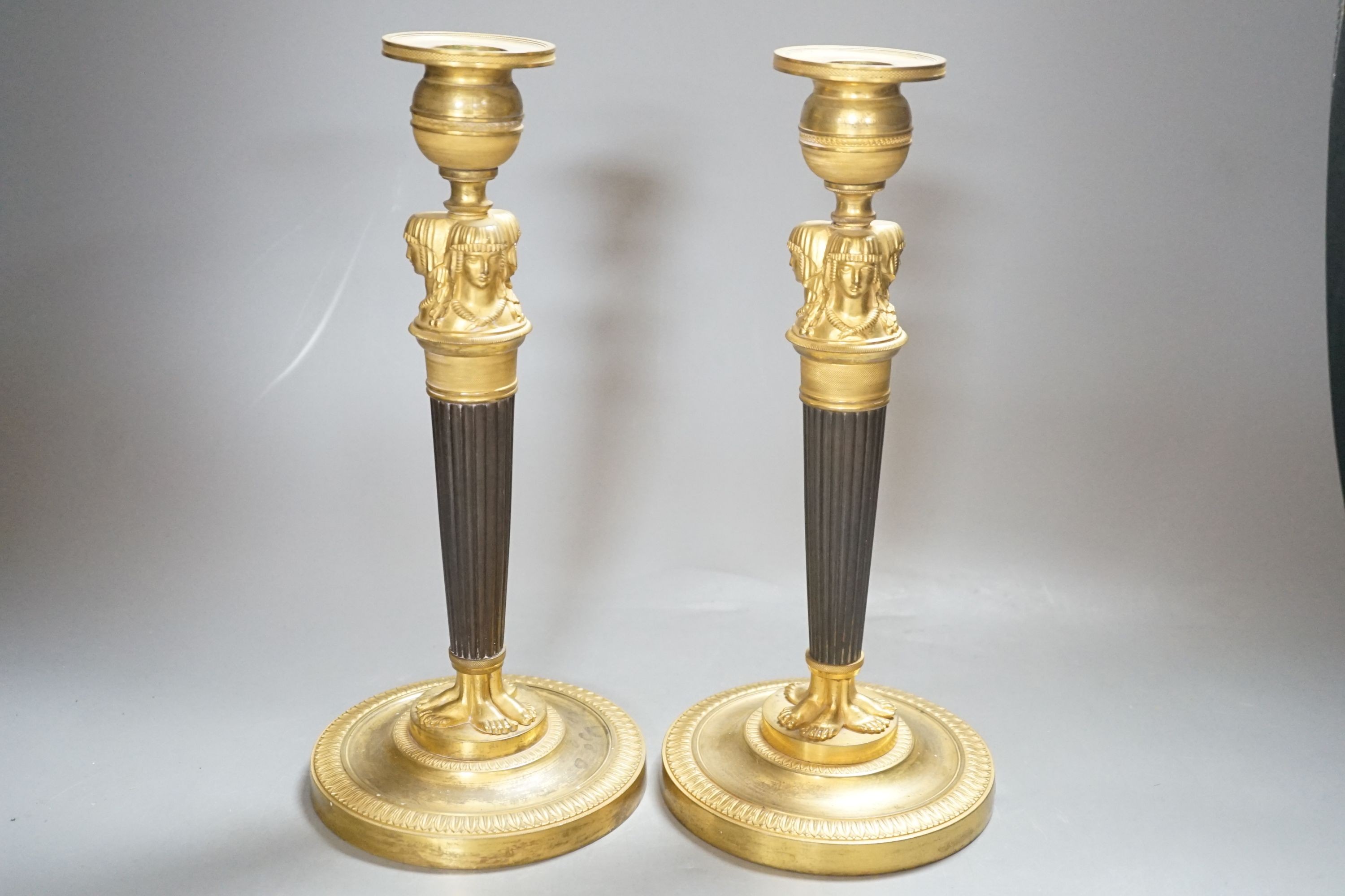 A pair of Empire style bronze and ormolu candlesticks - 29.5cm tall